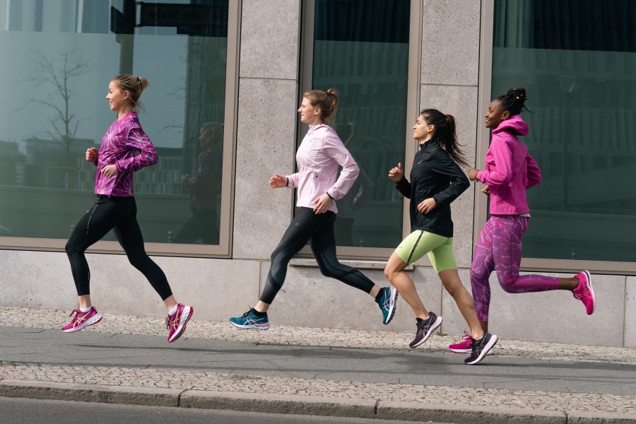 vier glückliche laufende Frauen